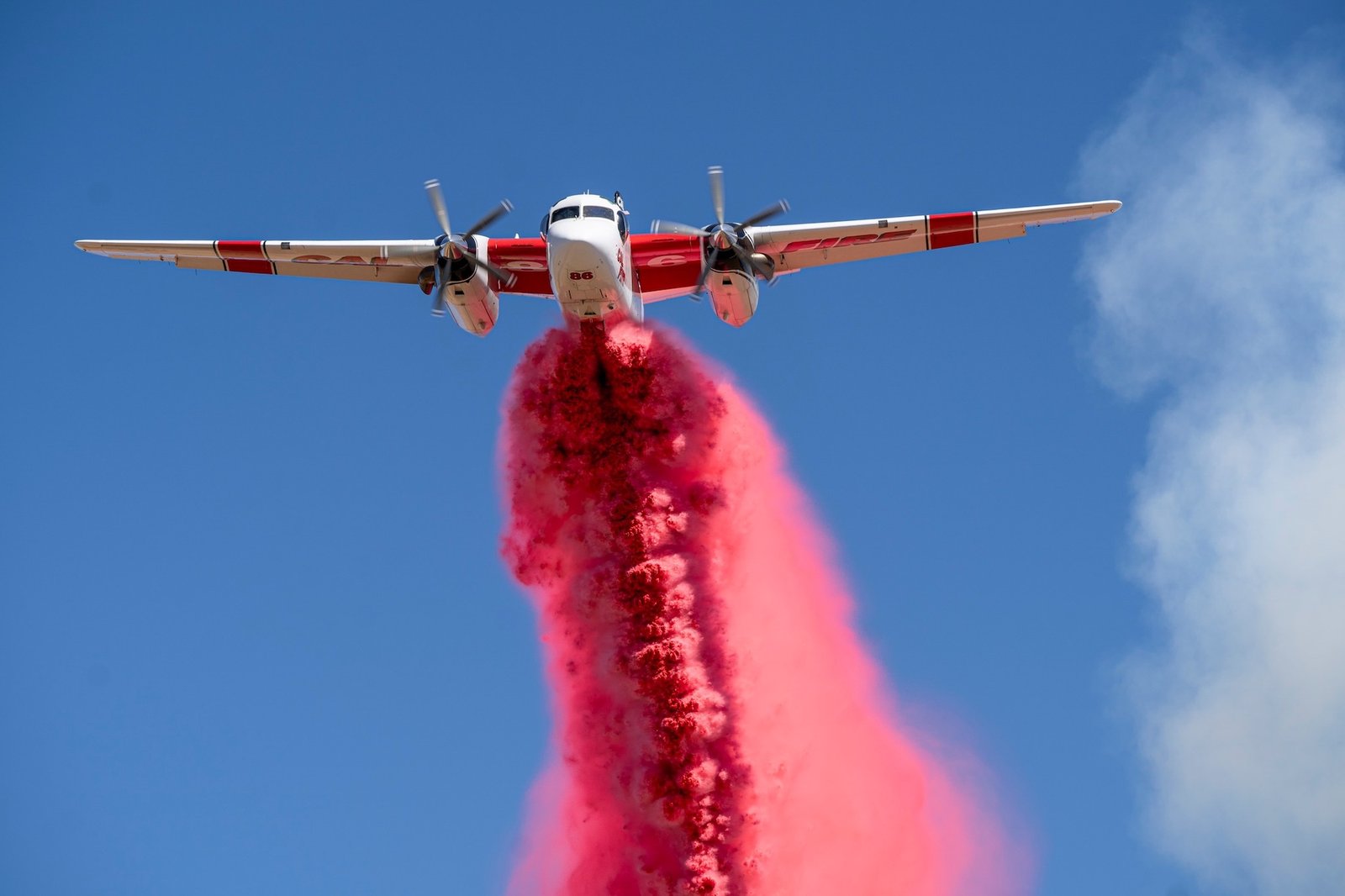 fire plane dropping red fire retardant