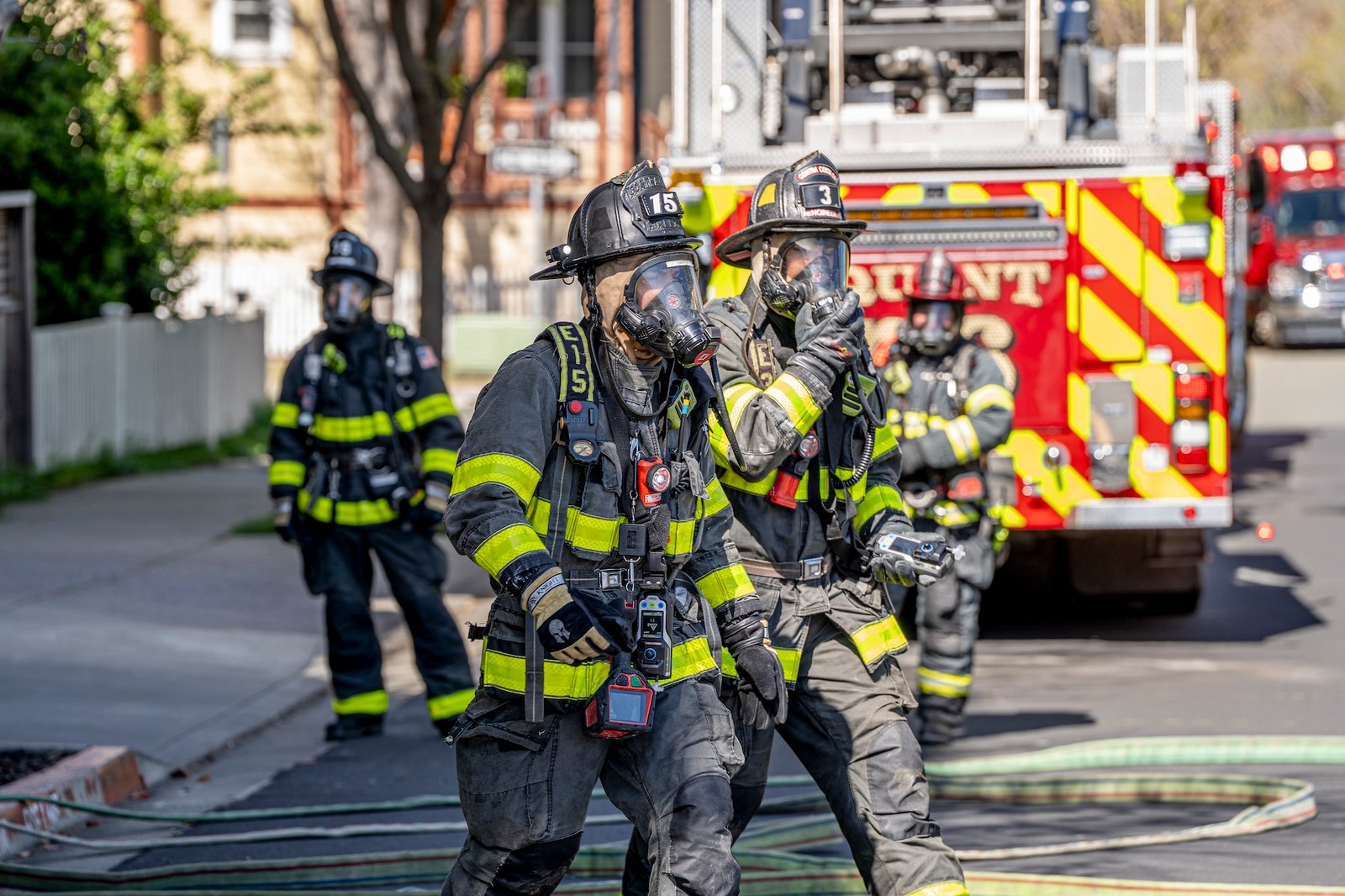 firefighters with all of their breathing gear on heading into a fire