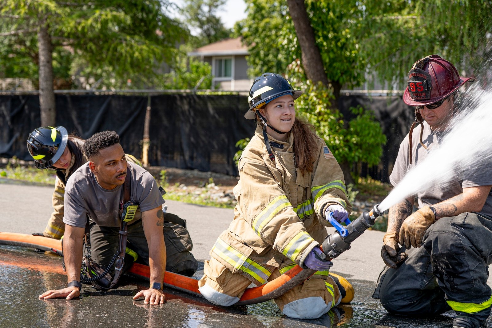 teenage camper spraying a fire hose at GEC